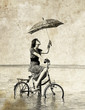 Girl with umbrella on bike. Photo in old image style.