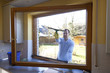 Mann beim Fenster putzen