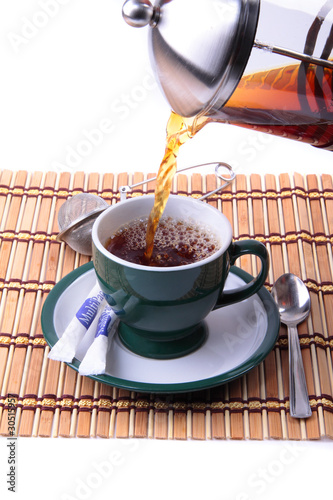 Photo: Pouring fresh tea kettle into green cup Pouring fresh tea kettle into green cup