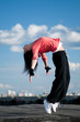woman dancing hip hop over blue sky