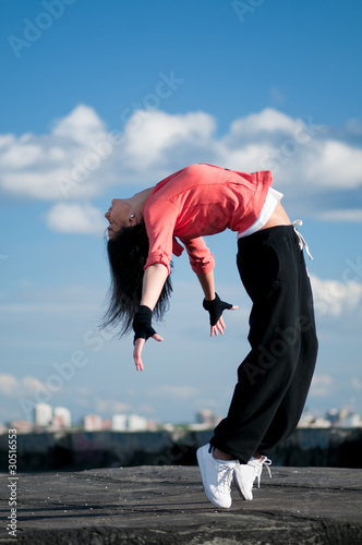Photo: woman dancing hip hop over blue sky woman dancing hip hop over blue sky