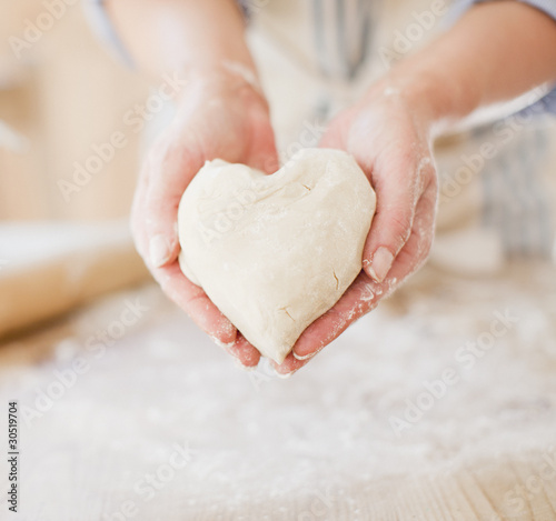Foto: Close up of woman holding heart-shape dough Close up of woman holding heart-shape dough