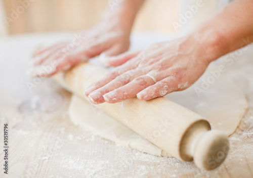 Foto: Close up of woman rolling dough with rolling pin on kitchen counter Close up of woman rolling dough with rolling pin on kitchen counter