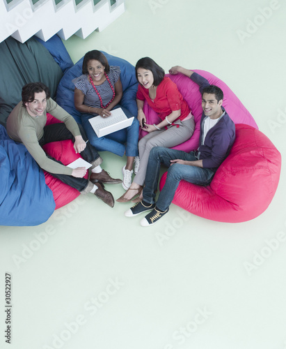 Photo: Smiling business people sitting in bean bag chairs Smiling business people sitting in bean bag chairs