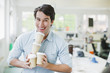 Smiling businessman balancing coffee cups