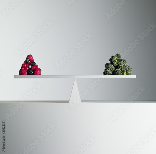 Photo: Berries and broccoli balanced on opposite ends of seesaw Berries and broccoli balanced on opposite ends of seesaw