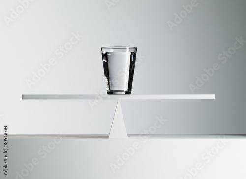 Photo: Glass of water balancing on middle of seesaw Glass of water balancing on middle of seesaw