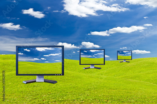 Photo: Lcd monitor on green grass meadow Lcd monitor on green grass meadow