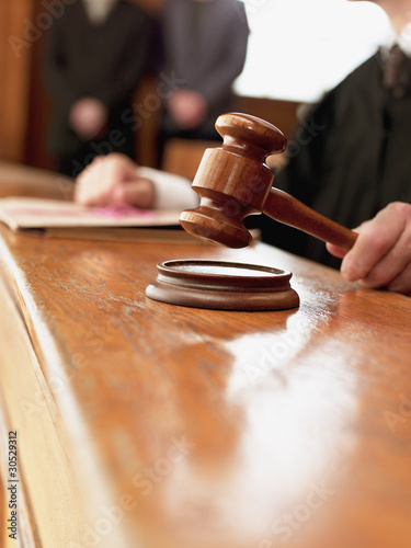 Photo: Close up of judge raising gavel in courtroom Close up of judge raising gavel in courtroom