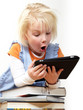 Little blond girl is reading on touchpad