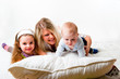 Foto: Mutter mit zwei Kindern auf dem Bett spielen Mutter mit zwei Kindern auf dem Bett spielen
