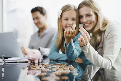 Foto: Mother and daughter comparing coins Mother and daughter comparing coins
