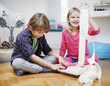 Brother and sister playing with adding machine and adding machine tape