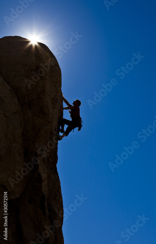 Photo: Rock climber clinging to a cliff. Rock climber clinging to a cliff.