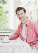 Smiling man drinking coffee in cafe