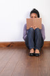Black girl sitting on floor at home reading book