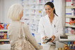 Pharmacist holding security device for customer in drug store