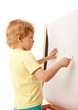 Four-year old boy drawing picture on easel