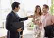 Realtor handing couple keys to home