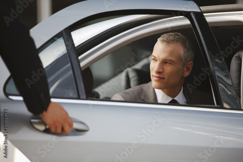 Photo: Chauffeur opening car door for businessman Chauffeur opening car door for businessman