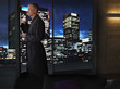Man drinking coffee and looking at night cityscape