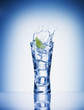 Lime slice splashing water from glass