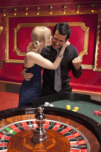 Photo: Girlfriend kissing winning boyfriend at roulette table Girlfriend kissing winning boyfriend at roulette table