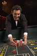 Man gathering winnings at craps table