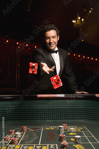 Photo: Man throwing dice at craps table Man throwing dice at craps table