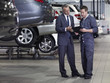Businessman talking to mechanic in auto repair shop