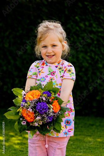 Foto: Kind mit Blumenstrauß. Geschenk für Muttertag Kind mit Blumenstrauß. Geschenk für Muttertag