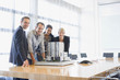 Business people looking at model building in conference room