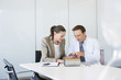 Business people looking at circuit board together in conference room