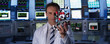 Scientist holding molecule model in control room