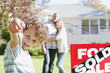 Boy holding new house keys next to sold sign