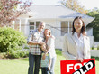 Realtor standing with family in front of new house