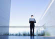 Businessman holding glowing laptop on balcony
