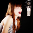 girl singing to the microphone in a studio