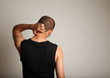 Man scratching back of head against wall
