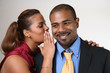 Photo: Woman whispering in husband's ear Woman whispering in husband's ear