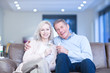 Happy couple drinking champagne on couch