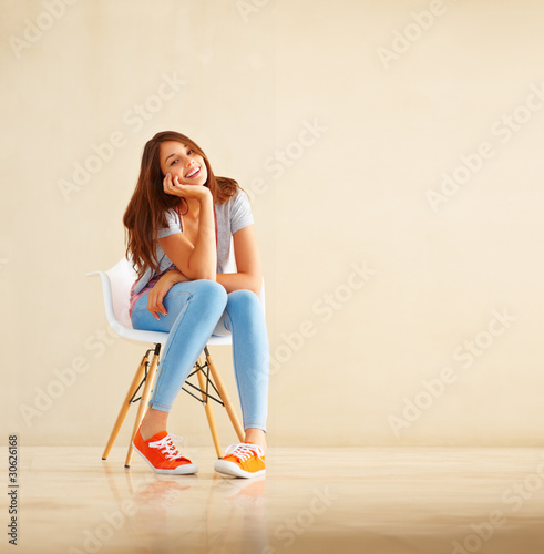 Photo: Girl sitting on chair and smiling Girl sitting on chair and smiling