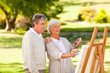 Retired couple painting in the park Retired couple painting in the park