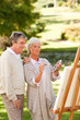Senior couple painting in the park Senior couple painting in the park