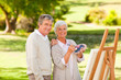 Senior couple painting in the park Senior couple painting in the park