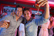 Two Young Men Having Fun In Busy Bar