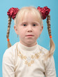 Portrait of a cute girl with blond hair in pigtails