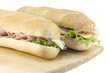 two fresh subs on cutting board two fresh subs on cutting board