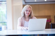 Mature woman using laptop at table