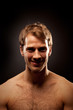 Dramatic portrait of young man with evil smile against black bac